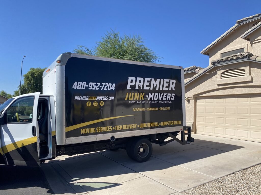 Premier Junk Movers box truck in a residential driveway